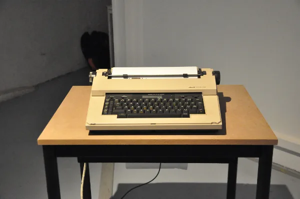 TypeWriterBot : une machine à écrire électrique posée sur une table, dans une salle d'exposition